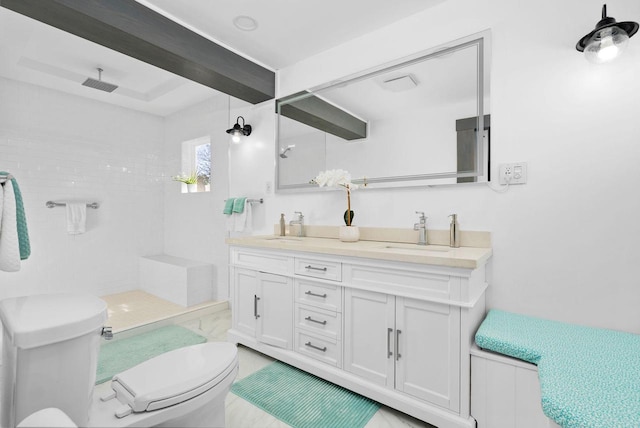 bathroom featuring beamed ceiling, vanity, toilet, and a tile shower