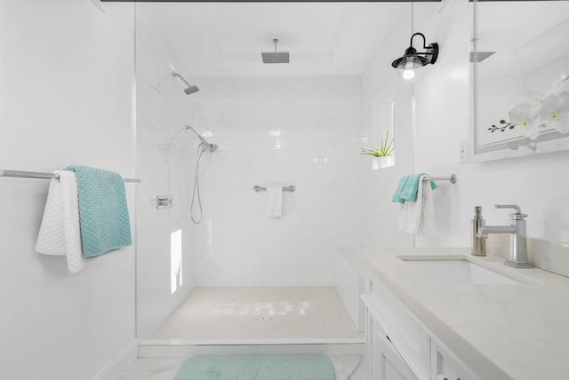 bathroom with vanity and a tile shower