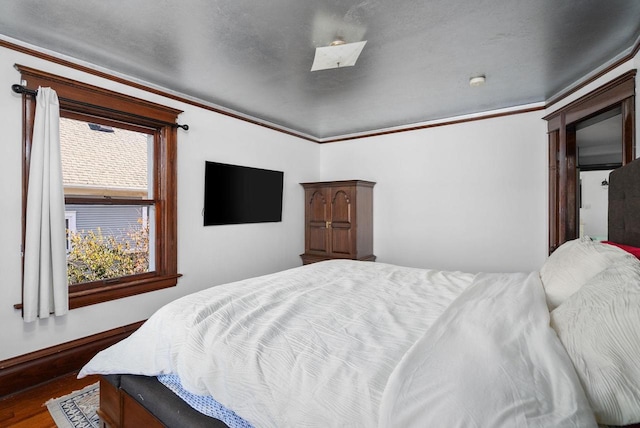 bedroom with dark hardwood / wood-style flooring and ornamental molding