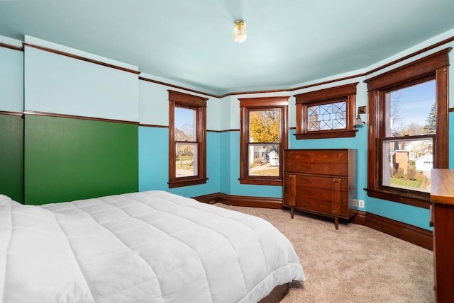 bedroom with multiple windows and light carpet