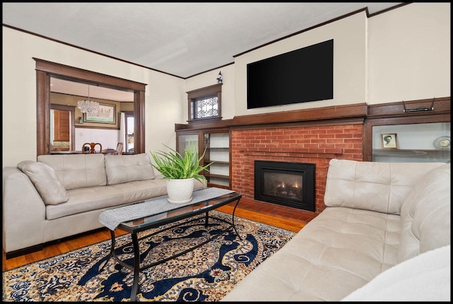 living room with hardwood / wood-style floors, crown molding, and a fireplace