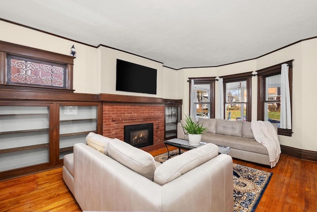 living room with ornamental molding, a fireplace, and light hardwood / wood-style floors