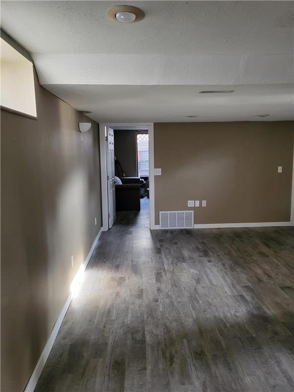 empty room featuring dark hardwood / wood-style floors and a textured ceiling