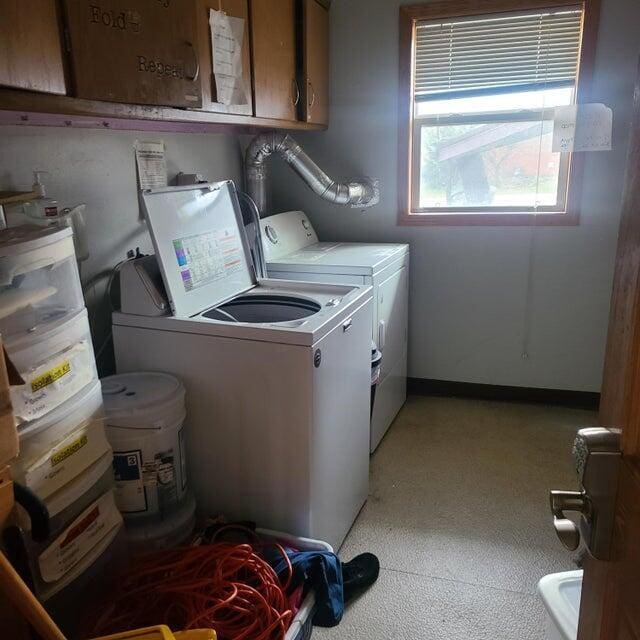 washroom with cabinets and washing machine and dryer