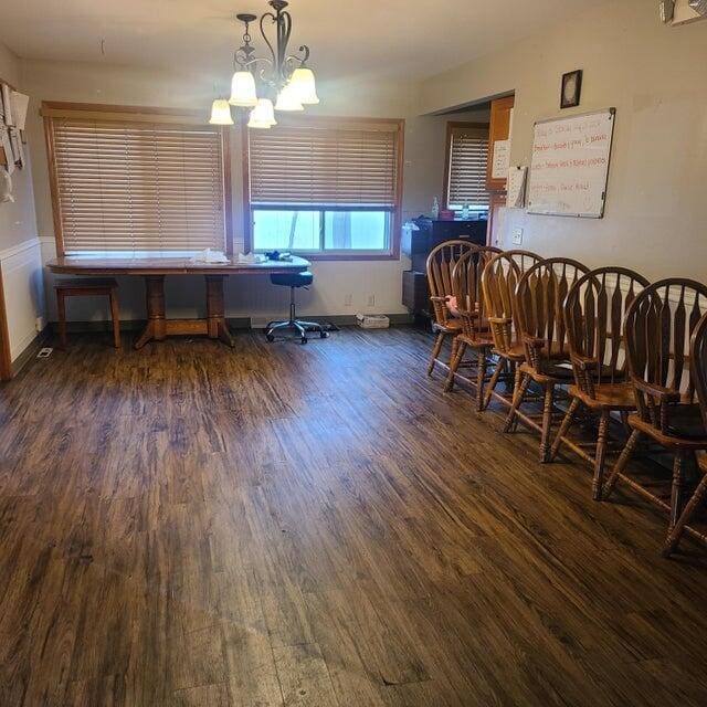 dining area with dark hardwood / wood-style flooring and a notable chandelier