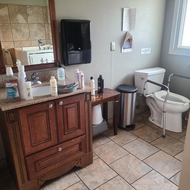 bathroom featuring vanity, tile patterned floors, and toilet