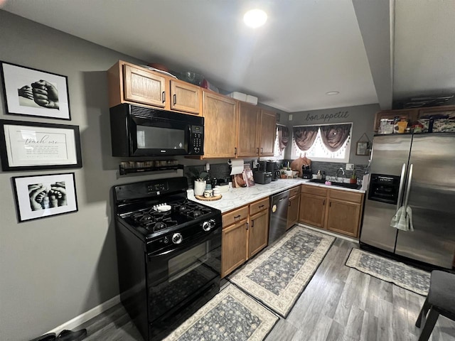 kitchen featuring dark hardwood / wood-style floors, sink, and black appliances