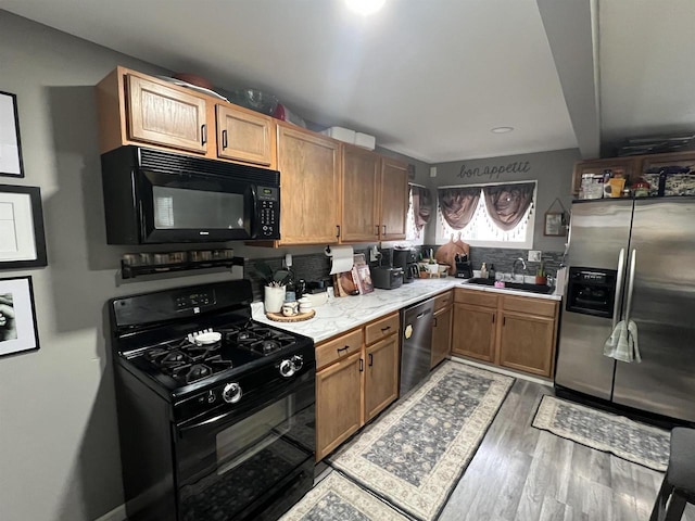 kitchen with sink, hardwood / wood-style flooring, and black appliances