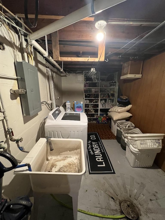 basement featuring sink, electric panel, and independent washer and dryer