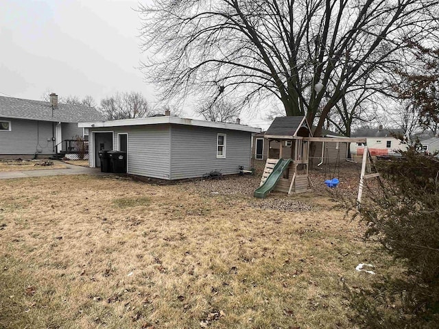 rear view of house with a playground and a lawn