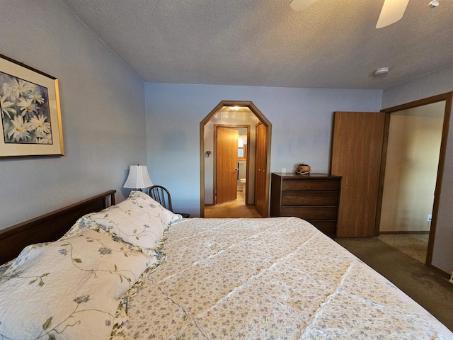 carpeted bedroom with a textured ceiling and ceiling fan