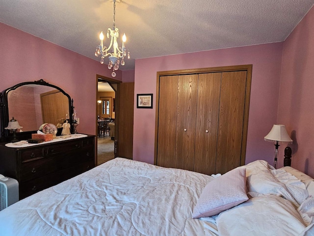 bedroom with an inviting chandelier, a closet, and a textured ceiling