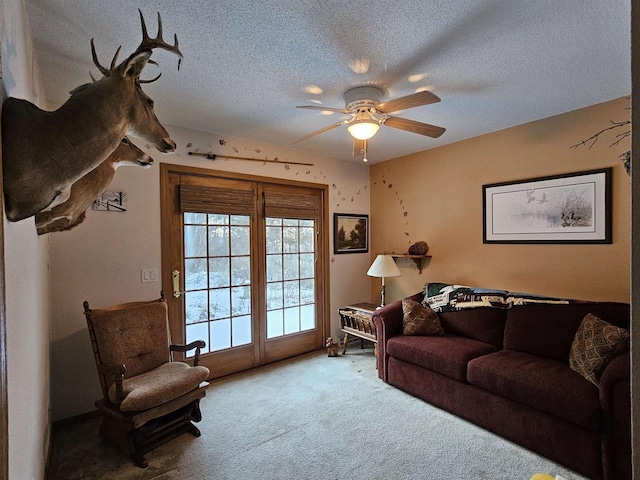 living room featuring ceiling fan, carpet floors, and a textured ceiling