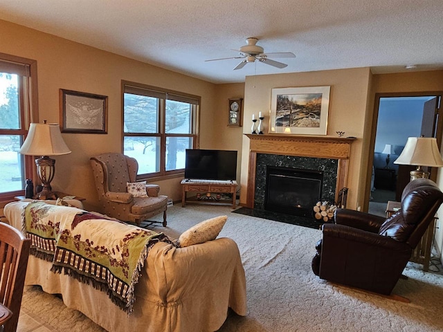 carpeted living room featuring ceiling fan, a fireplace, and a textured ceiling