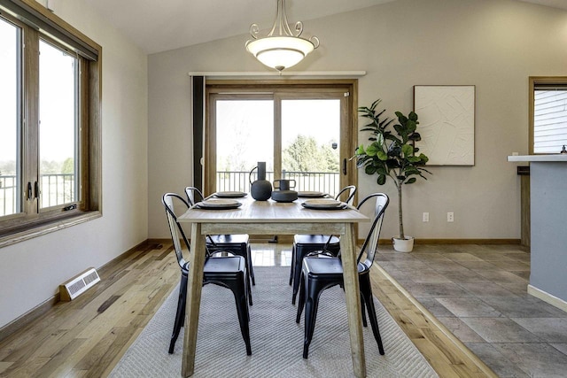 dining room with hardwood / wood-style flooring and vaulted ceiling