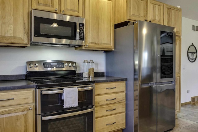 kitchen featuring appliances with stainless steel finishes and light tile patterned floors