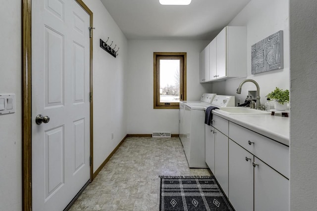 laundry area featuring cabinets, sink, and washing machine and clothes dryer