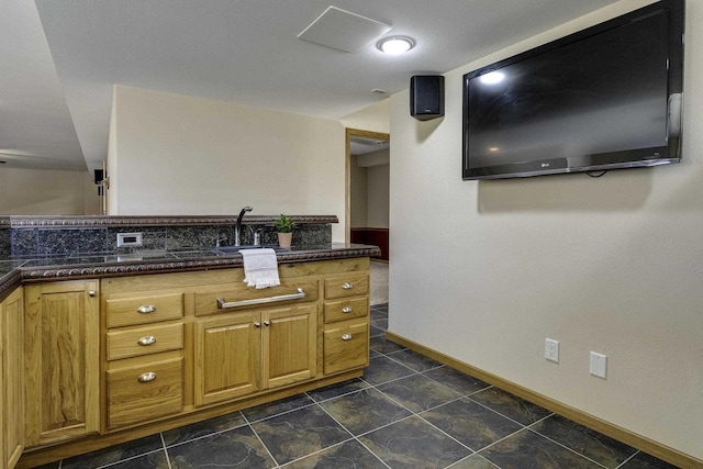 kitchen featuring dark stone countertops and sink