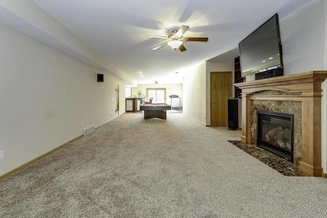 unfurnished living room featuring ceiling fan, carpet, pool table, and a fireplace