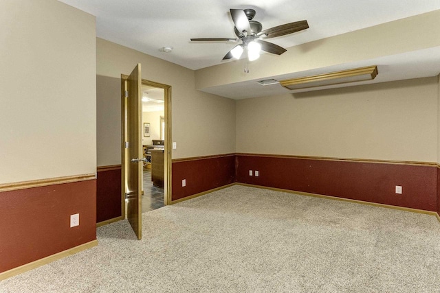 spare room with carpet floors, wooden walls, and ceiling fan