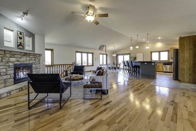 living room with a fireplace, light hardwood / wood-style flooring, and high vaulted ceiling