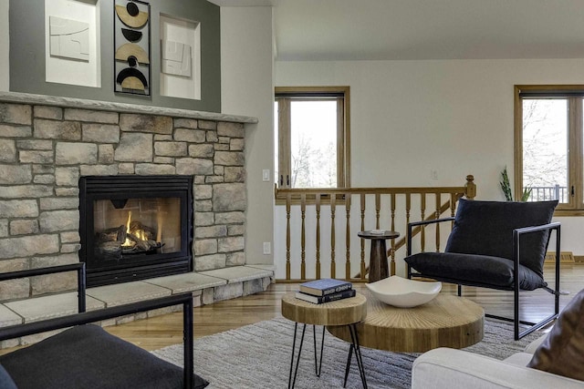 sitting room featuring a stone fireplace and hardwood / wood-style floors