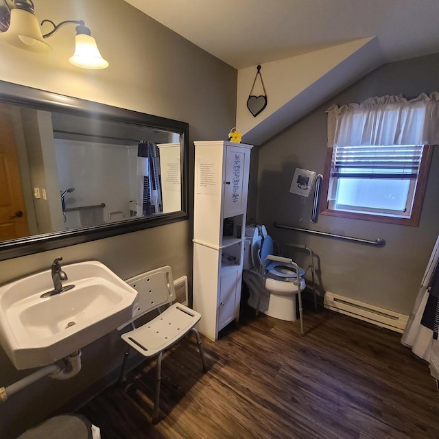 bathroom with vaulted ceiling, a baseboard radiator, wood-type flooring, sink, and toilet