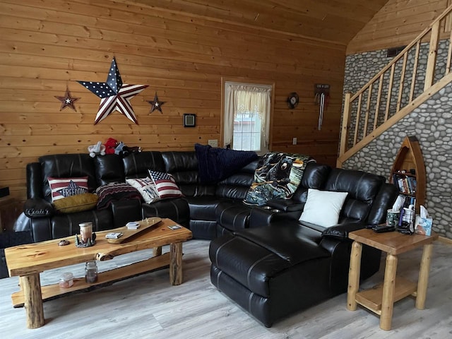 living room with hardwood / wood-style flooring, lofted ceiling, and wood walls