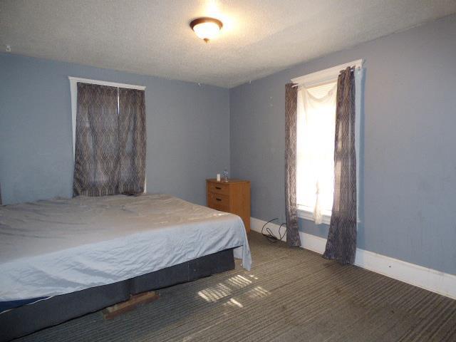 carpeted bedroom featuring a textured ceiling