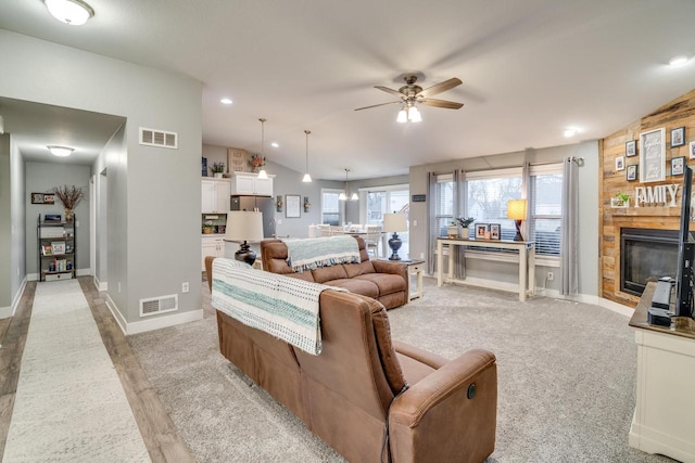 living room with lofted ceiling, light colored carpet, and ceiling fan