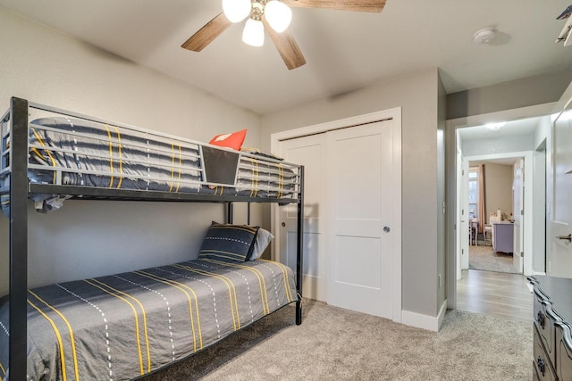 carpeted bedroom with ceiling fan and a closet