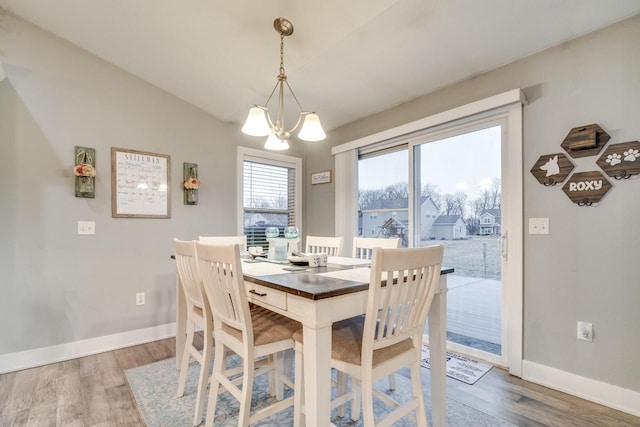 dining area featuring hardwood / wood-style flooring and a chandelier