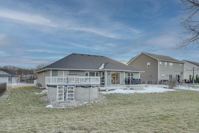 rear view of property featuring a wooden deck and a lawn