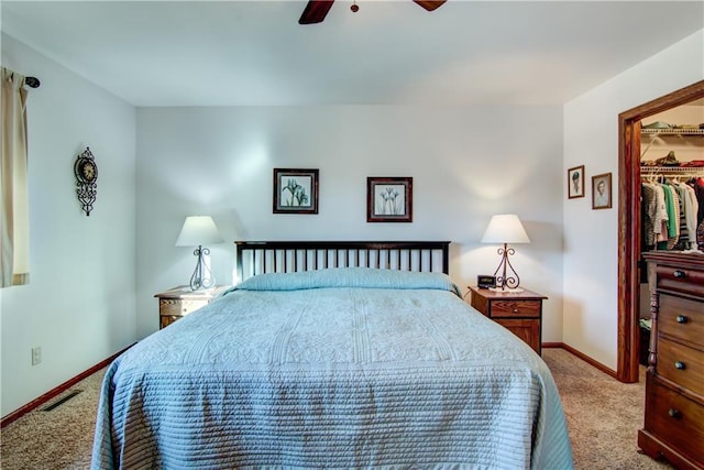 carpeted bedroom with a walk in closet, a closet, and ceiling fan