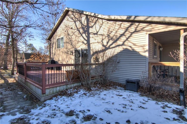 view of snow covered exterior featuring a wooden deck