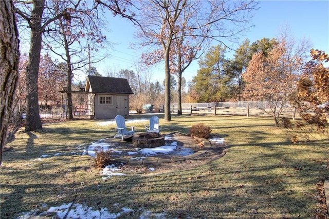 view of yard with a shed and an outdoor fire pit