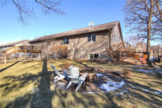 rear view of house featuring a yard, a fire pit, and a wooden deck