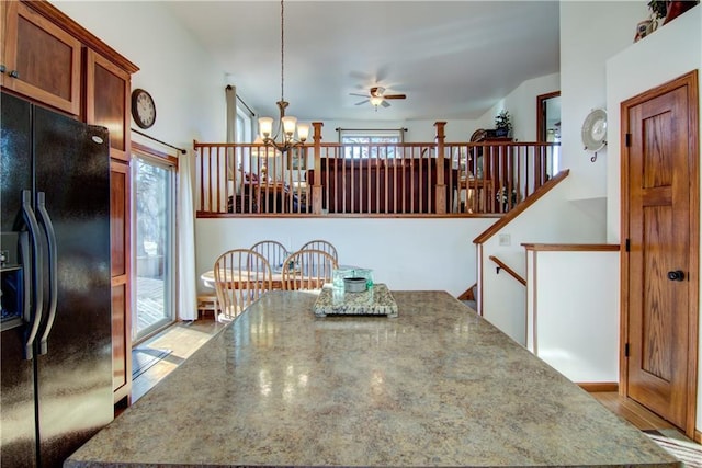 dining room featuring ceiling fan with notable chandelier and light hardwood / wood-style floors