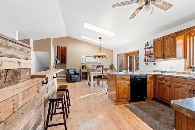 kitchen with lofted ceiling with skylight, dishwasher, hanging light fixtures, kitchen peninsula, and light hardwood / wood-style flooring