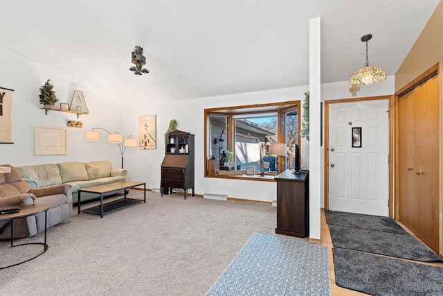 entrance foyer with lofted ceiling and light colored carpet