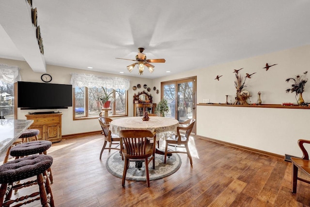 dining area with hardwood / wood-style flooring and ceiling fan