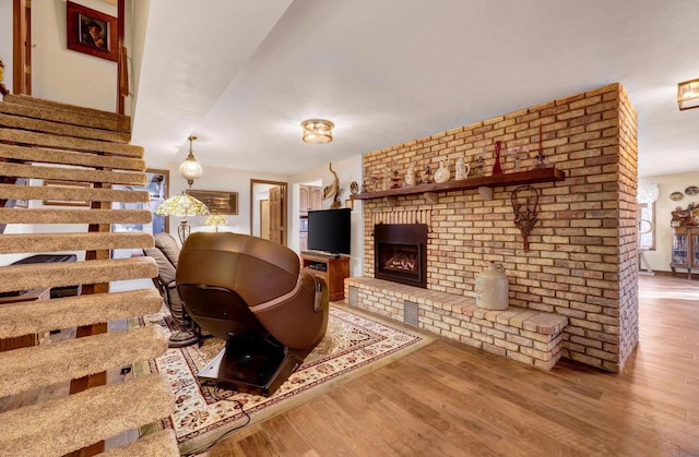 living room featuring a healthy amount of sunlight, a fireplace, and light wood-type flooring