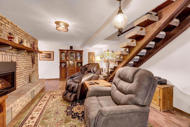 living room with a brick fireplace and light hardwood / wood-style flooring