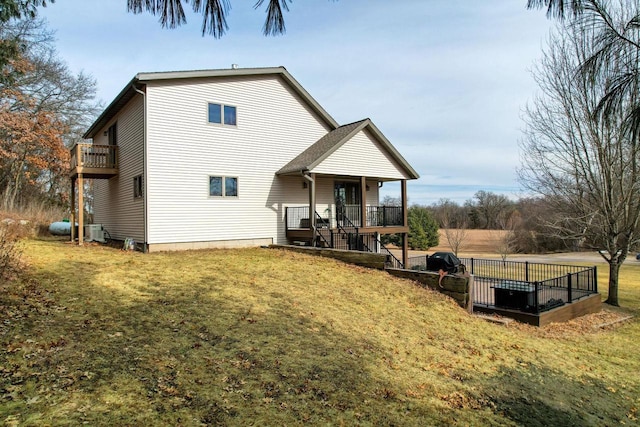 back of property with a porch, central air condition unit, and a lawn