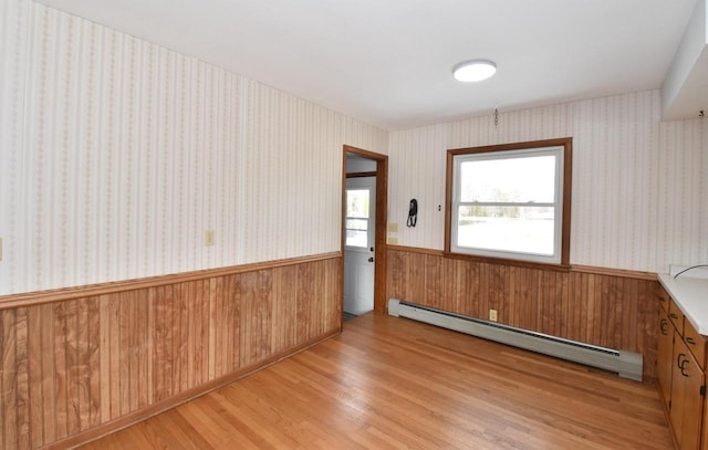 spare room with a baseboard heating unit and light wood-type flooring