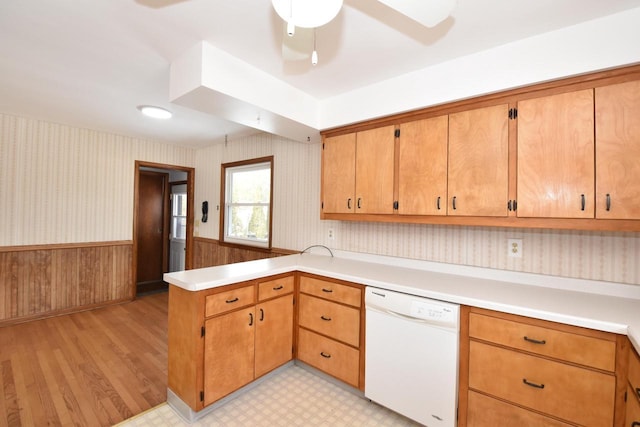 kitchen with white dishwasher, light hardwood / wood-style floors, kitchen peninsula, and ceiling fan