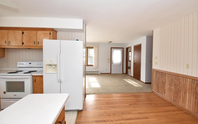 kitchen with white appliances, a baseboard radiator, and light hardwood / wood-style floors