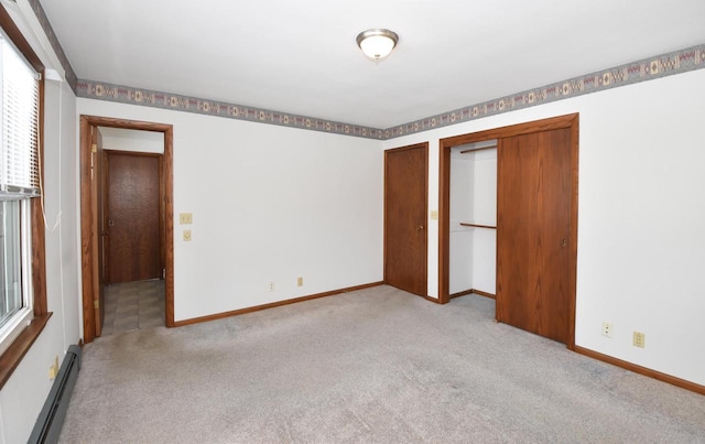 unfurnished bedroom with a baseboard heating unit and light carpet