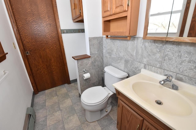 bathroom with vanity, tile walls, toilet, and baseboard heating