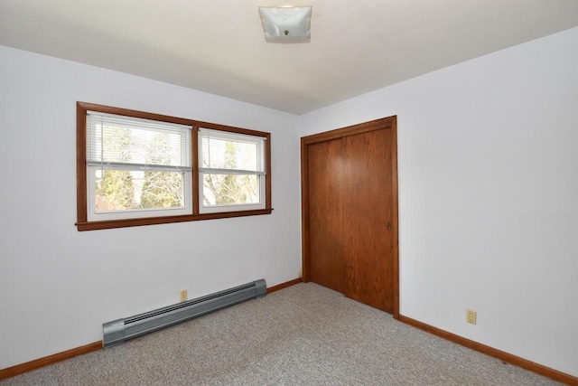 unfurnished bedroom featuring a baseboard radiator, light colored carpet, and a closet